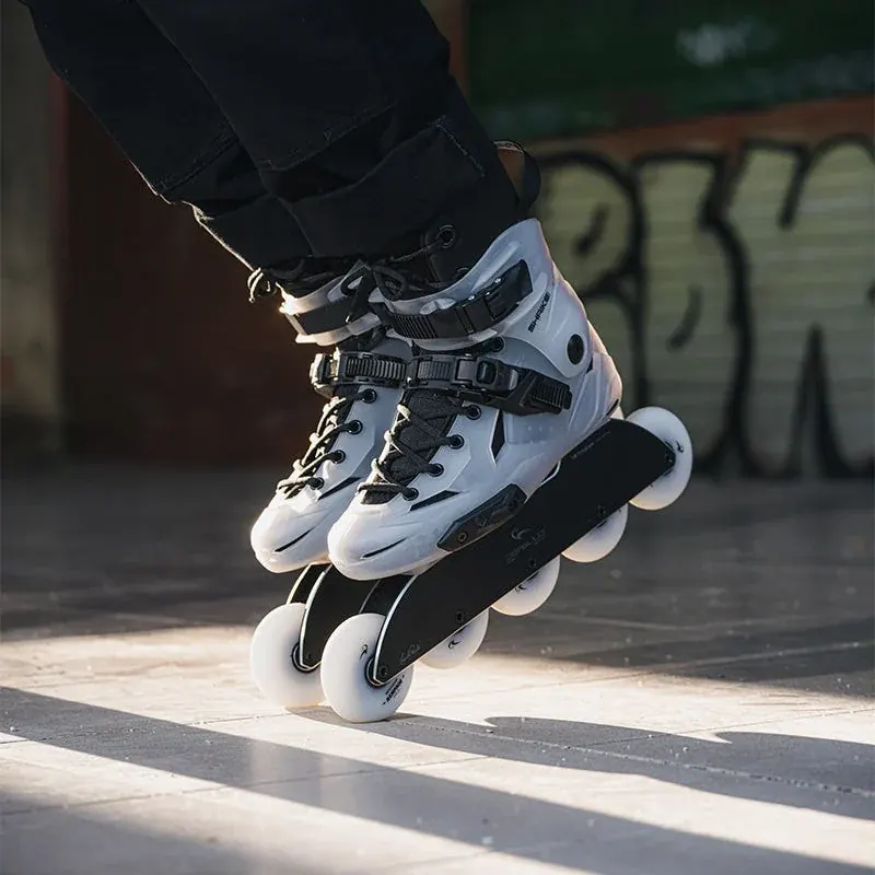 White and black Flying Eagle inline skates leaning into a turn on smooth pavement.